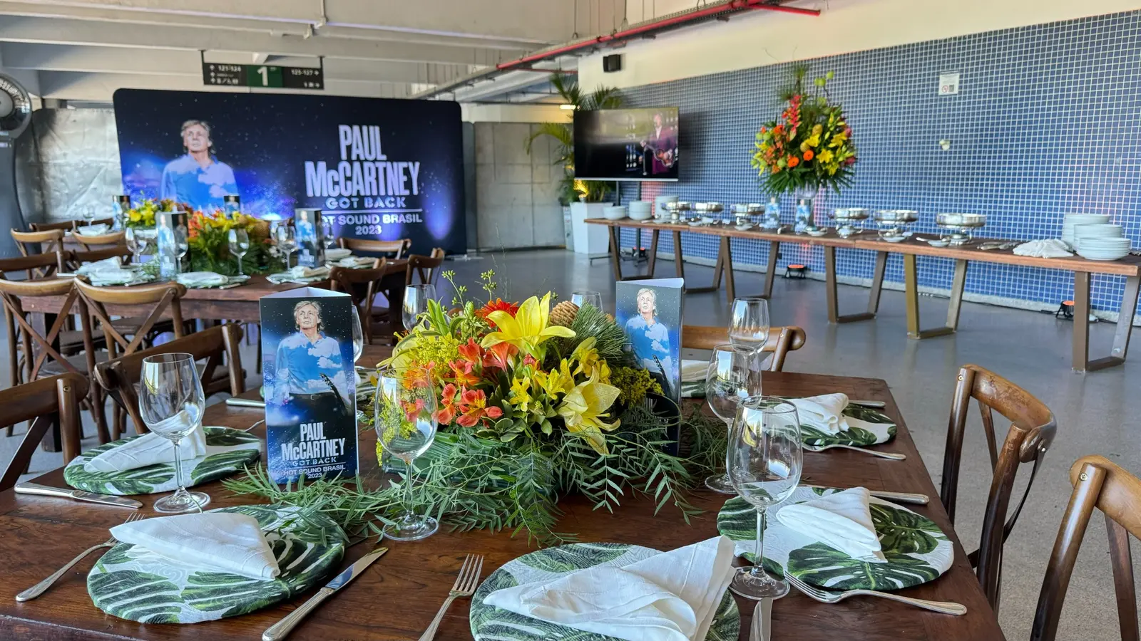 Ambiente de catering preparado para Paul McCartney, com mesas postas e buffet.